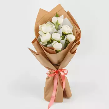 Букет из 7 белых пионов в крафте с розовой лентой