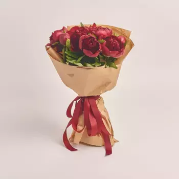 Букет из 7 красных пионов в крафте