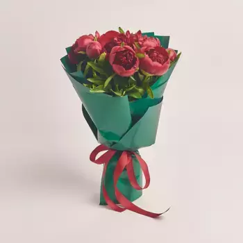 Букет из 7 красных пионов в зеленой бумаге