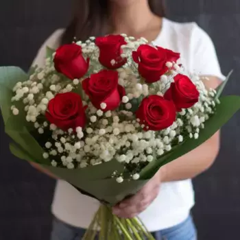 Букет из 7 красных роз и гипсофил в зеленой упаковке