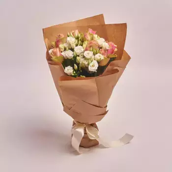 Букет из 7 розовых роз и 4 белых лизиантусов в крафте