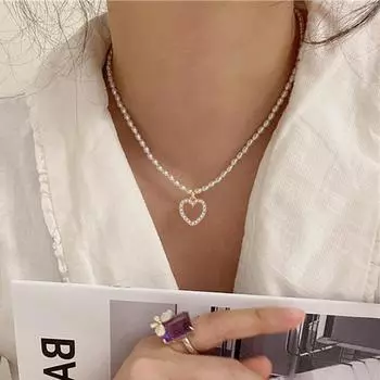 Модная женщина с изысканными ювелирными украшениями в форме сердца в простом и благородном ожерелье золотой